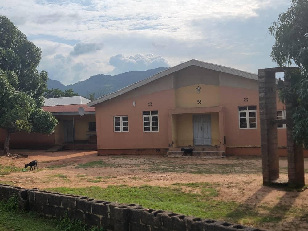 First Baptist Church building with a pitched roof at Takete-Ide, hills visible behind